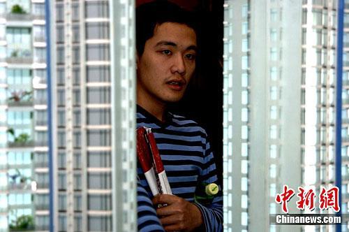 资料图：一位年轻人早早来到福州一售楼部看楼盘。中新社记者 王东明 摄